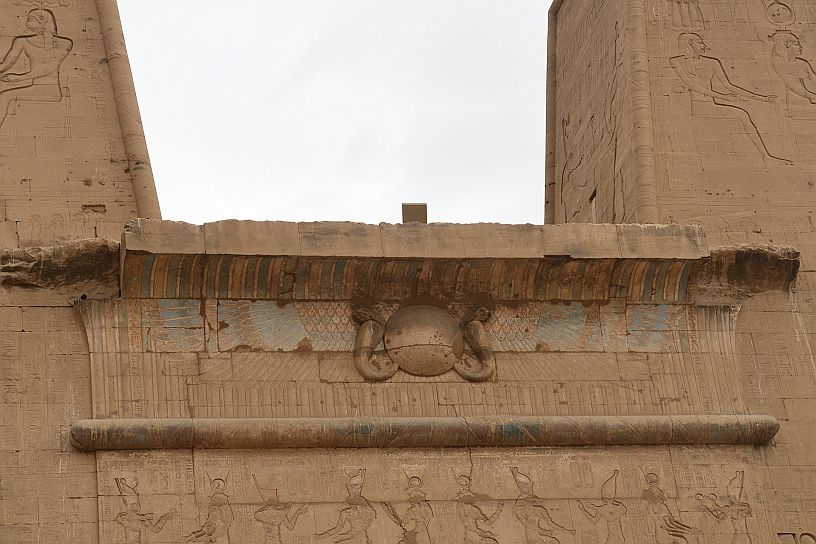 04 MAK_6249.jpg - Sull’architrave dell’ingresso del tempio si trova il sole alato primordiale, un simbolo di protezione divina attorniato da due cobra, simboli di regalità e forza distruttrice contro i nemici degli dei e del faraone.